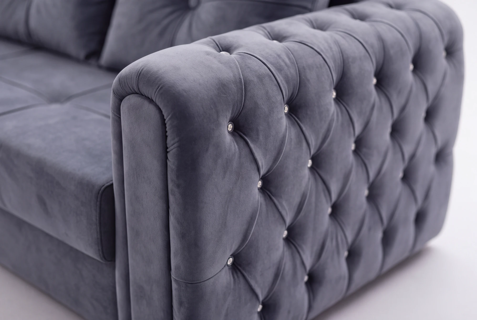 Close-up of the diamond-tufted arm with crystal buttons